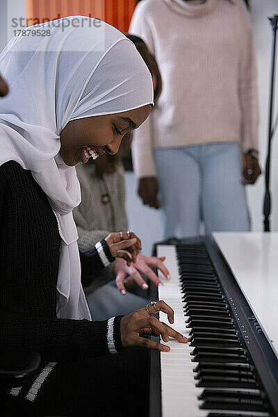 Mädchen im Hidschab spielt Klavier im Aufnahmestudio
