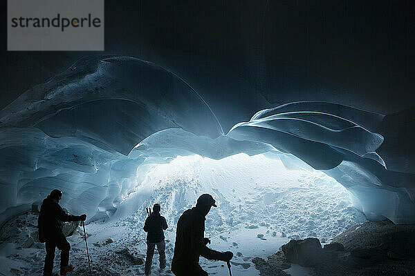 Silhouetten von Männern beim Wandern in der Gletschereishöhle  Selkirk Mountains  Kanada