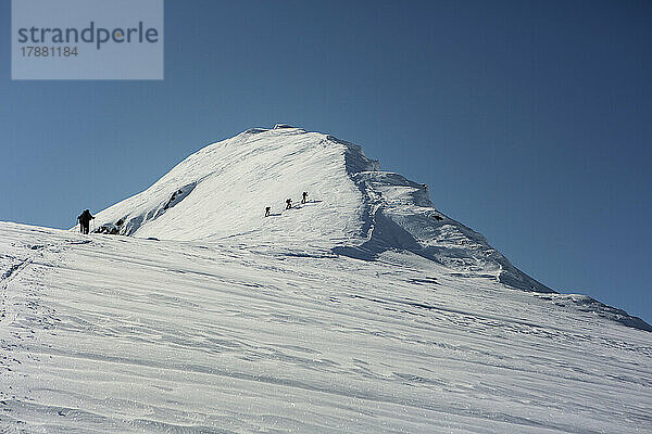 Bergsteiger erklimmen sonnigen  verschneiten Berggipfel  Selkirk Mountains  Kanada