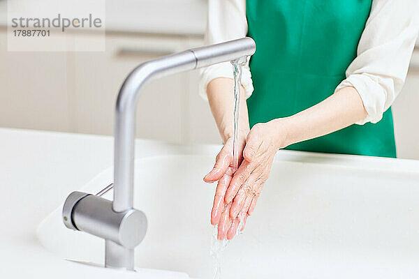 Japanische Seniorin beim Händewaschen