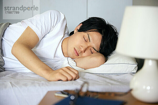 Japanischer Mann im Bett