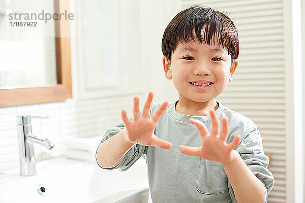 Japanisches Kind wäscht sich zu Hause die Hände