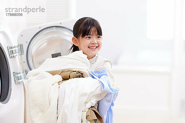 Japanisches Kind wäscht zu Hause Wäsche