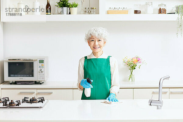 Japanische Seniorin putzt Küche