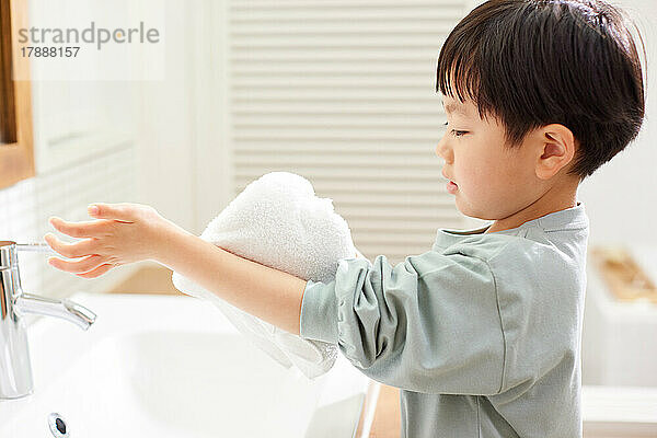 Japanisches Kind wäscht sich zu Hause die Hände