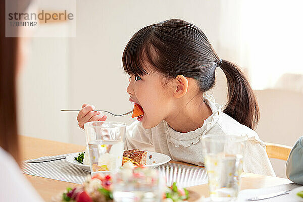Japanisches Kind  das zu Hause isst