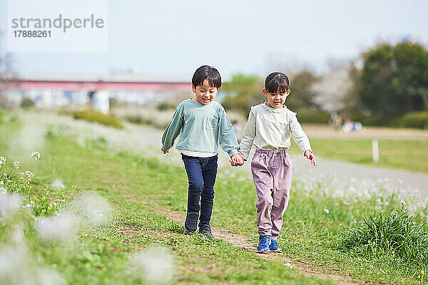 Japanische Kinder und blühende Kirschblüten