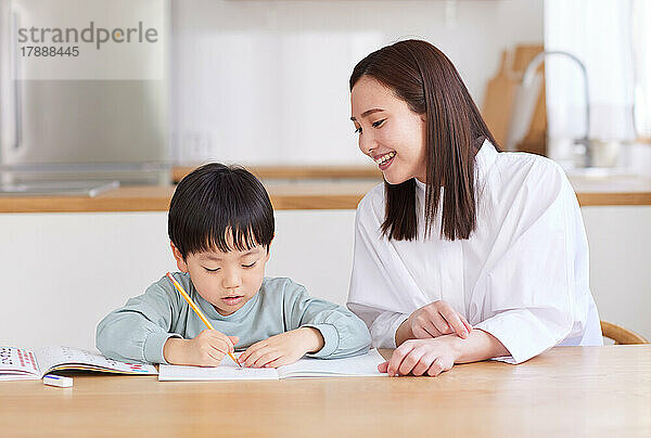 Japanisches Kind und Mutter lernen zu Hause