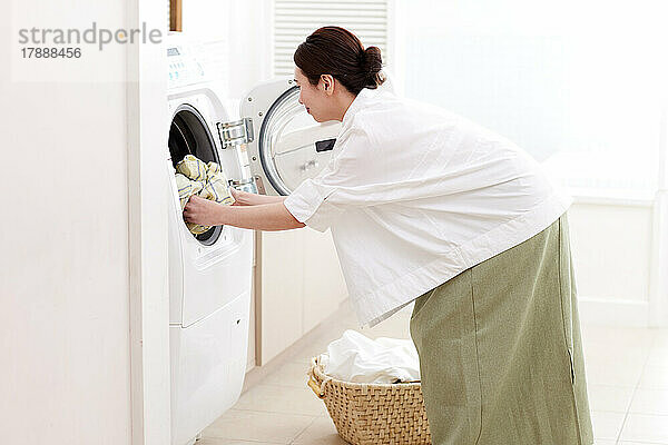 Japanerin wäscht zu Hause Wäsche