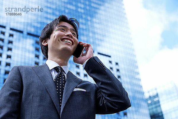 Japanischer Geschäftsmann am Telefon im Geschäftsviertel