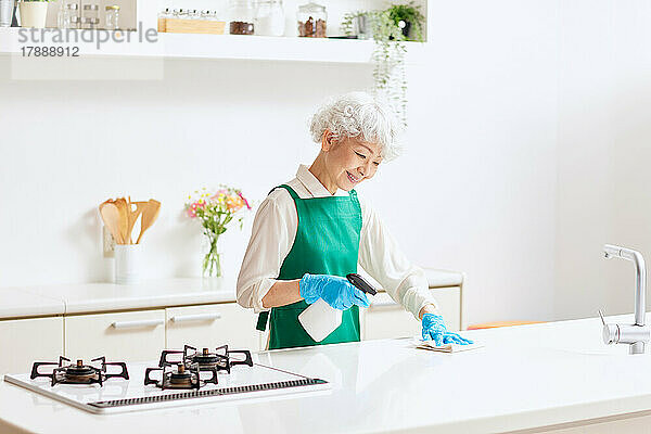 Japanische Seniorin putzt Küche