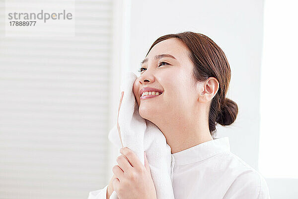 Japanische Frau wäscht zu Hause Gesicht