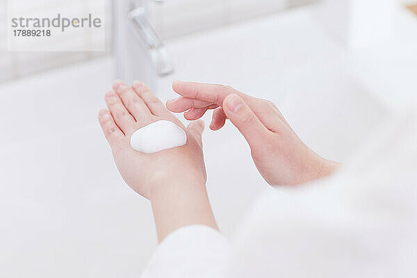 Japanerin wäscht sich die Hände mit schäumender Handseife