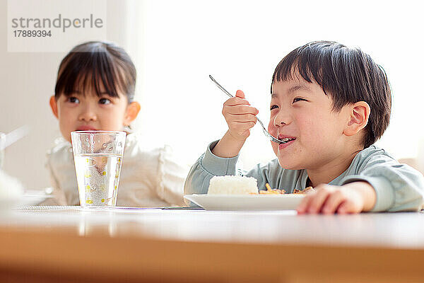 Japanische Kinder essen zusammen zu Hause