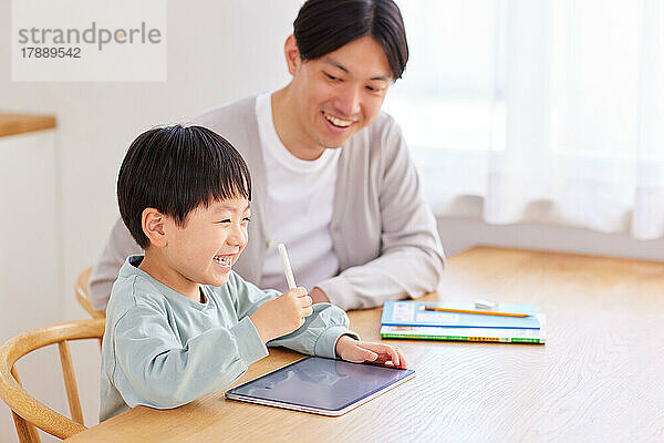 Japanisches Kind und Vater lernen zu Hause