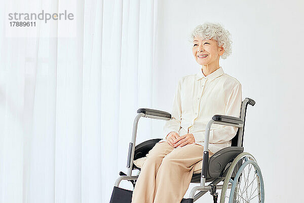 Japanische Seniorin im Rollstuhl