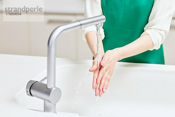 Japanische Seniorin beim Händewaschen