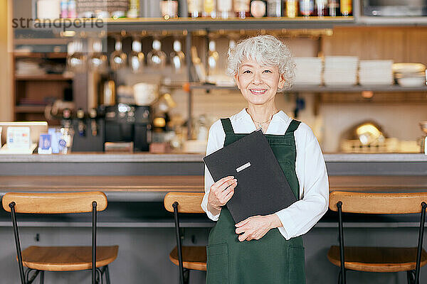 Japanische ältere Frau  die in einem Restaurant arbeitet