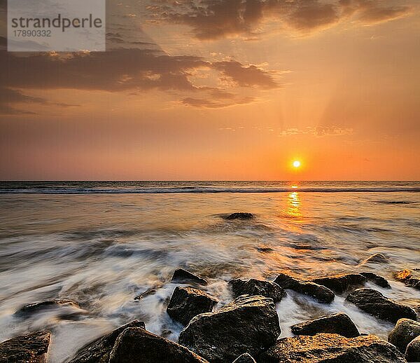 Tropischen Strand Urlaub Hintergrund  Wellen und Felsen am Strand bei Sonnenuntergang mit schönen Wolkenlandschaft