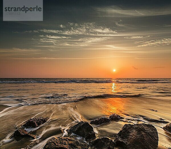 Tropischen Strand Urlaub Hintergrund  Wellen und Felsen am Strand bei Sonnenuntergang mit schönen Wolkenlandschaft