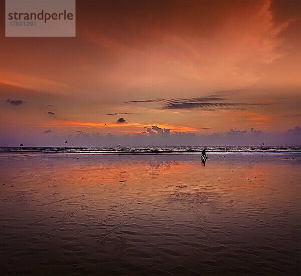 Ehepaar spaziert am Strand bei romantischem Sonnenuntergang. Baga Strand. Goa  Indien  Asien