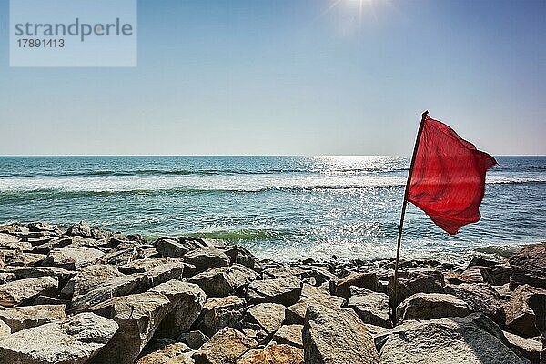 Gefahr  Rote Flagge am felsigen Strand  die das Schwimmen verbietet