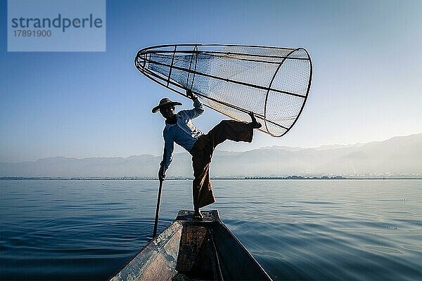 Myanmar Reiseattraktion Wahrzeichen  traditionelle birmanische Fischer Silhouette Balancieren mit Fischernetz am Inle-See in Myanmar berühmt für ihre unverwechselbaren einbeinigen Ruderstil  Blick vom Boot