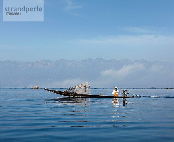 Myanmar Reiseattraktion Wahrzeichen  Traditionelle birmanische Fischer mit Fischernetz auf dem Inle-See in rasendem Motorboot