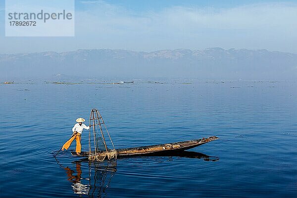 Myanmar Reiseattraktion Wahrzeichen  Traditionelle burmesische Fischer balancieren mit Fischernetz am Inle See  Myanmar berühmt für ihre unverwechselbare einbeinige Ruderstil