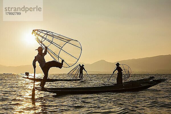 Myanmar Reiseattraktion Wahrzeichen  drei traditionelle birmanische Fischer am Inle-See  Myanmar berühmt für ihren unverwechselbaren einbeinigen Ruderstil