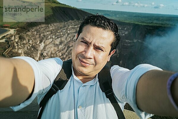 Abenteuerlustige Menschen machen ein Selfie an einem Aussichtspunkt. Nahaufnahme einer Person  die ein abenteuerliches Selfie macht  Tourist  der ein Selfie an einem Aussichtspunkt macht. Hübscher Tourist macht ein Selfie im Urlaub