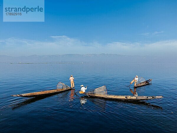 Traditionelle burmesische Fischer mit Fischernetzen auf Booten am Inle-See in Myanmar  der für seinen unverwechselbaren einbeinigen Ruderstil berühmt ist  sind das Wahrzeichen von Myanmar