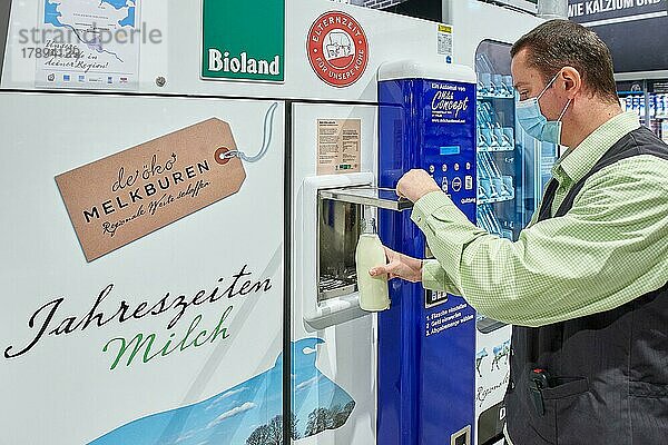 Mann zapft Milch aus einem Automaten  Edeka-Meyers  24537 Neumünster  Schleswig-Holstein  Deutschland  Europa
