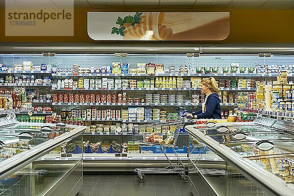 Frau schiebt Einkaufswagen an einem Regal entlang  nah&frisch-Markt  24497 Wanderup  Niedersachsen  Deutschland  Europa