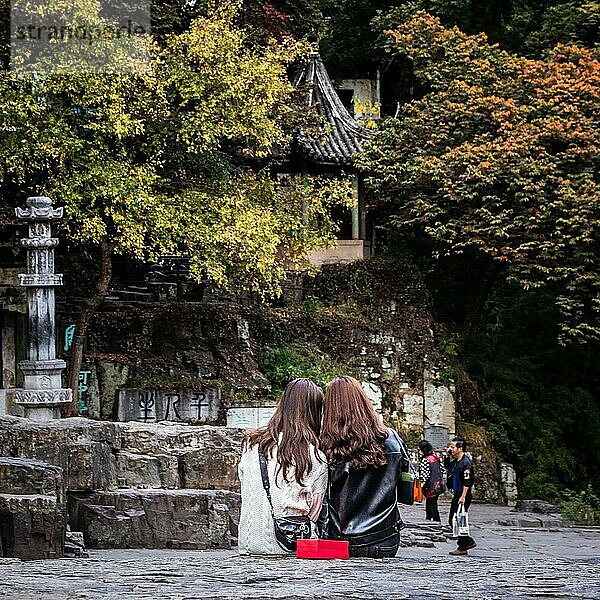 Freunde betrachten Bilder in einem Park in China