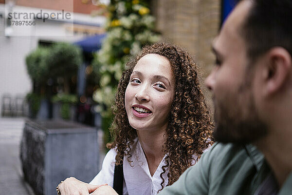 Smiling young woman talking with boyfriend