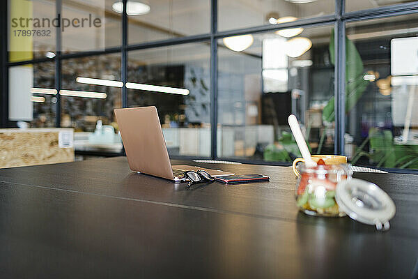 Laptop und Obst auf dem Tisch im Büro