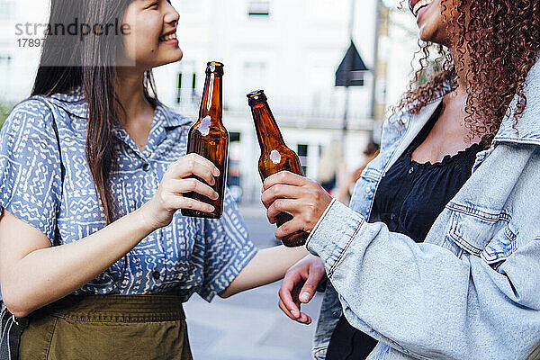 Glückliche Freunde stehen mit Bierflaschen