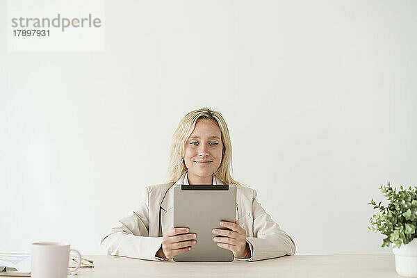 Geschäftsfrau nutzt Tablet-PC am Schreibtisch im Büro