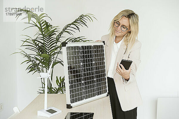 Frau schaut im Büro auf Solarpanel