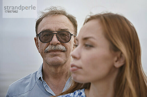 Älterer Mann mit Sonnenbrille steht Frau zur Seite