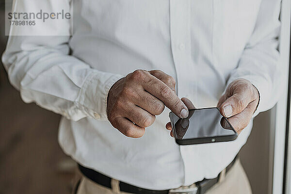 Hände eines Geschäftsmannes  der sein Smartphone nutzt
