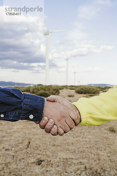 Kollegen beim Händeschütteln im Windpark