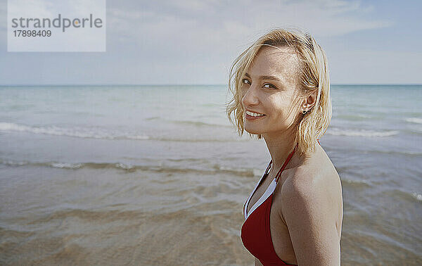 Glückliche Frau am Strand an einem sonnigen Tag