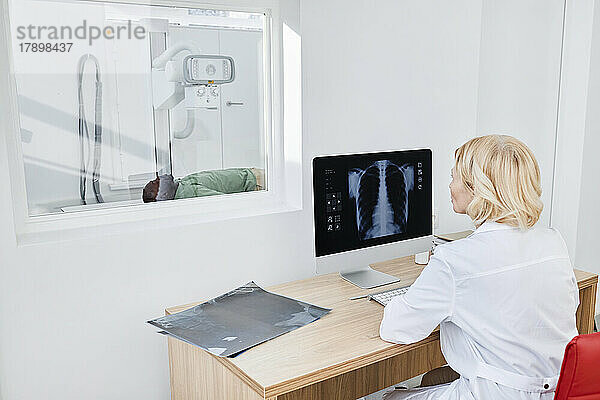 Radiologe macht Röntgenaufnahme eines Patienten in der Klinik