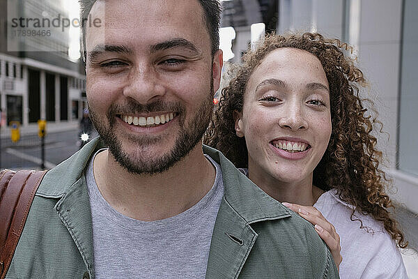Happy woman with curly hair behind friend