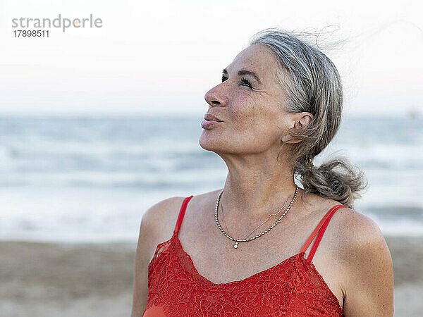Rentnerin mit grauen Haaren am Strand