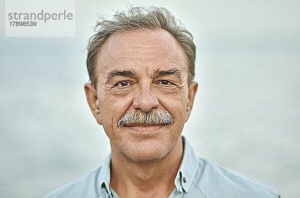 Lächelnder älterer Mann mit grauen Haaren