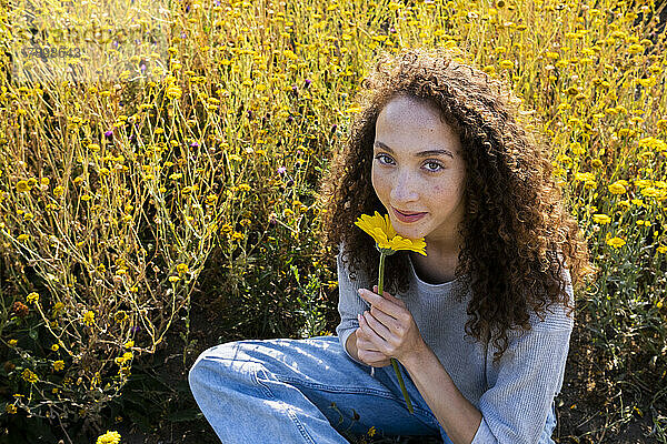Young woman with flower in park