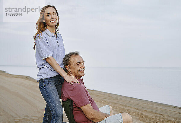 Glückliche Tochter und Vater entspannen sich am Strand